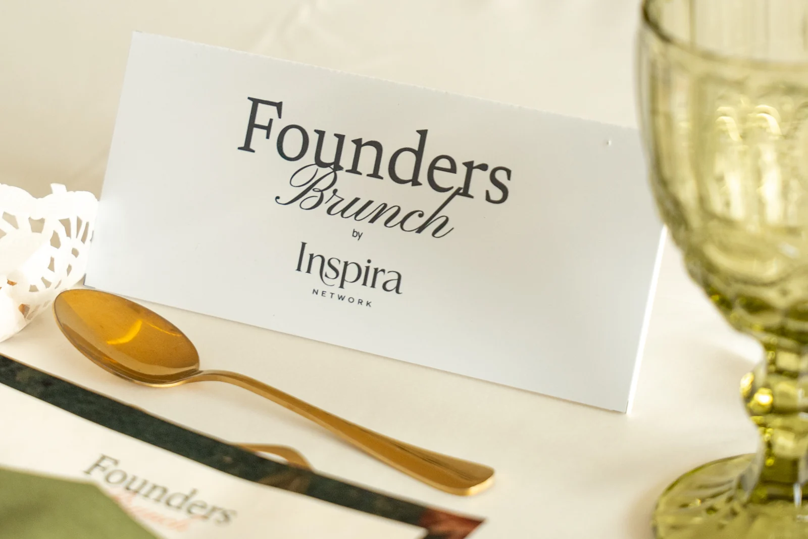 Mesa de Founders Brunch con su rótulo y cristalería verde.